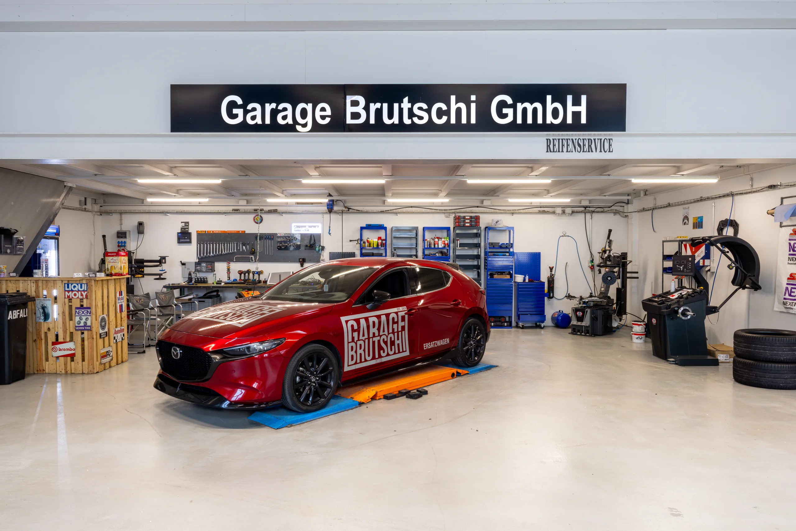 Mazda3 unter dem Garage Brutschi GmbH Schild in Zuzgen